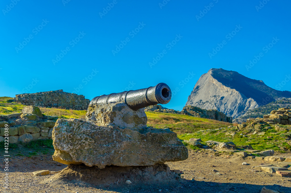 An old cast-iron cannon among the mountains.