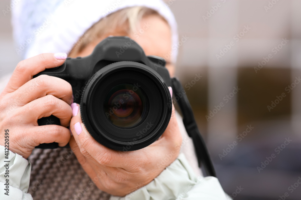 Photographer taking photo outdoors, focus on camera