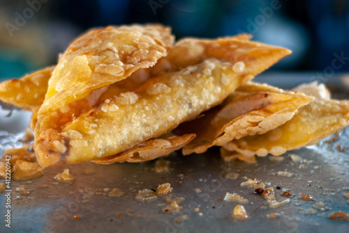 Fresh from the pan deep fried and oily Filipino style empanada with crispy wrapper and egg, vegetable and meat inside.