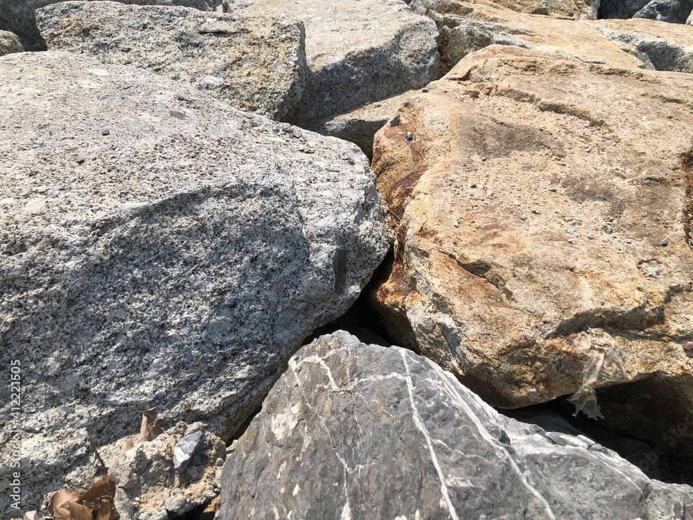 Natural background of big boulders or seaside pebbles up close. The surface of the beach in the ocean is paved with large polished round stones, gray of different sizes. Natural background of big boulders or seaside pebbles up close. The surface of the beach in the ocean is paved with large polished round stones, gray of different sizes.