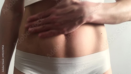 Woman on the light background, belly body part	
