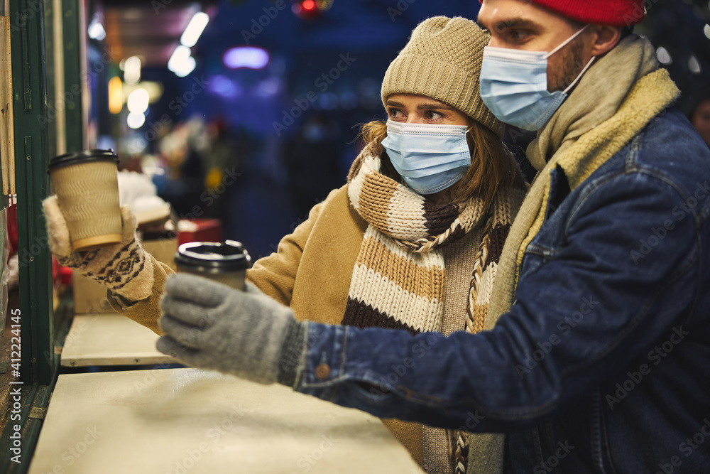 Young couple drinking coffee outdoors in winter Young couple drinking coffee outdoors in winter