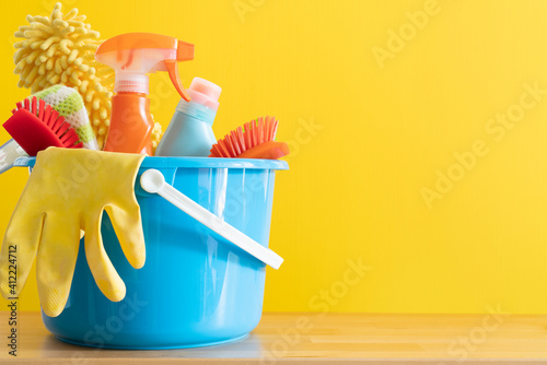 House cleaning product on wood table with yellow background, home service or housekeeping concept photo