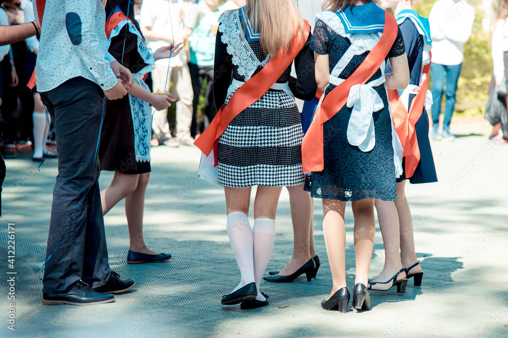 A group of high school students are standing near the school. A group of high school students are standing near the school.
