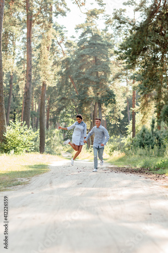 young couple in love having fun and enjoying the beautiful summer nature. woman and man, wearing in denim outfit are having date outdoors in the park. Romantic relationship. valentines day