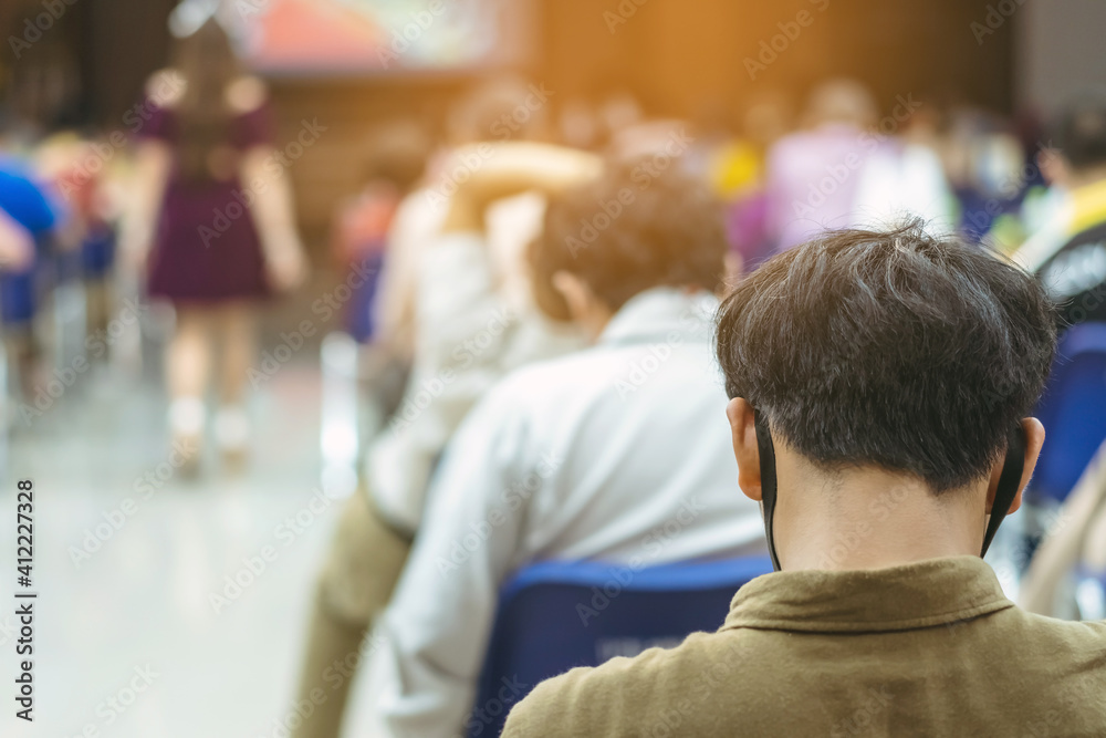 Back view of Asian man wear protective face mask to prevent Coronavirus(COVID-19) sitting on a chair for social distancing in auditorium. Conference concept in coronavirus pandemic.Selective focus. Back view of Asian man wear protective face mask to prevent Coronavirus(COVID-19) sitting on a chair for social distancing in auditorium. Conference concept in coronavirus pandemic.Selective focus.