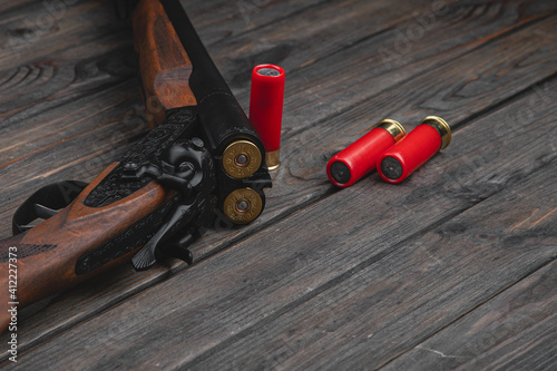 Fotografie Close-up shot of an old vintage double-barreled shotgun with triggers on a woode