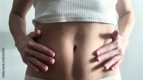 Woman on the light background, belly body part