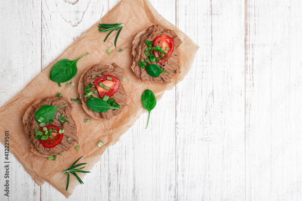 Sandwiches, canapes with chicken pate, tomatoes. On a white wooden background. Sandwiches, canapes with chicken pate, tomatoes. On a white wooden background.