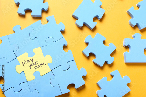 Jigsaw puzzle with phrase Play Your Part on yellow background, flat lay. Social responsibility concept photo