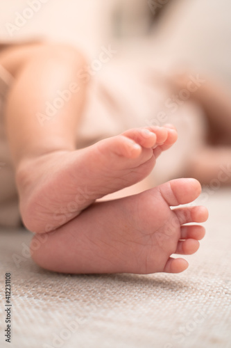 close up small feet of baby infant sleeping on soft bed. footprint details.  © Vajirawich