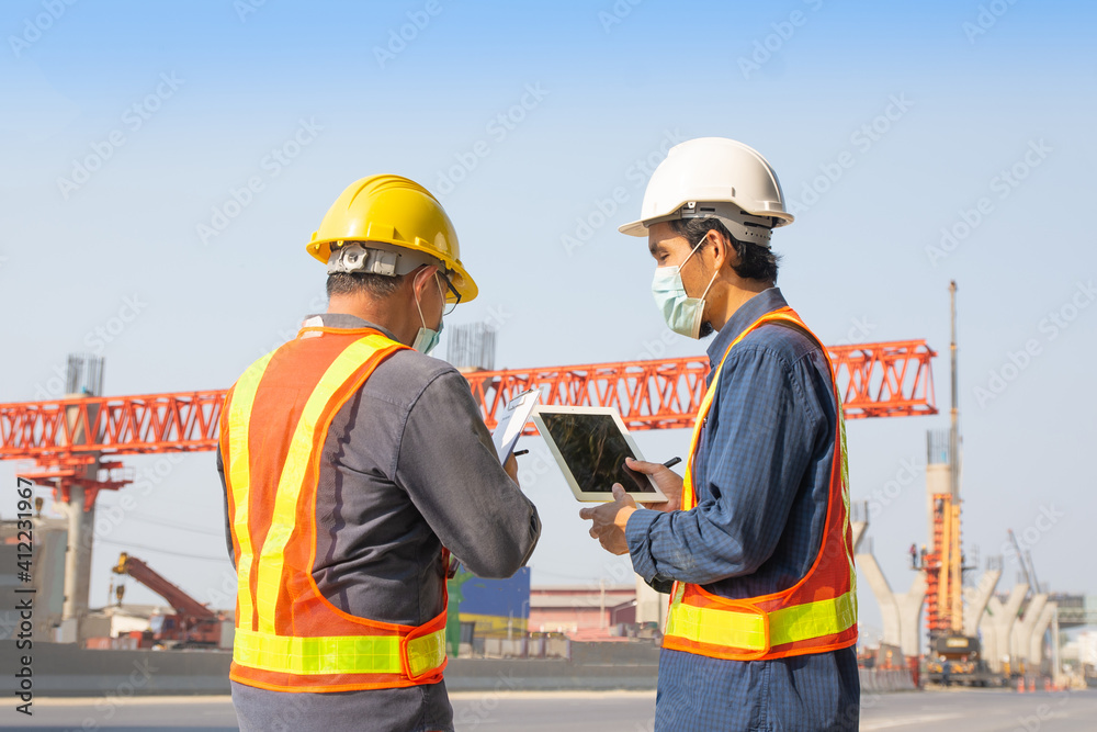 Two Engineer worker tablet working on site road construction, Asian man architecture builder building surveyor professional Two Engineer worker tablet working on site road construction, Asian man architecture builder building surveyor professional