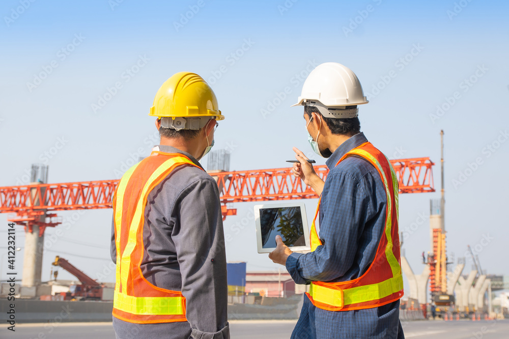 Two Engineer worker tablet working on site road construction, Asian man architecture builder building surveyor professional Two Engineer worker tablet working on site road construction, Asian man architecture builder building surveyor professional