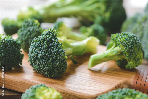 Board with fresh broccoli cabbage on wooden background