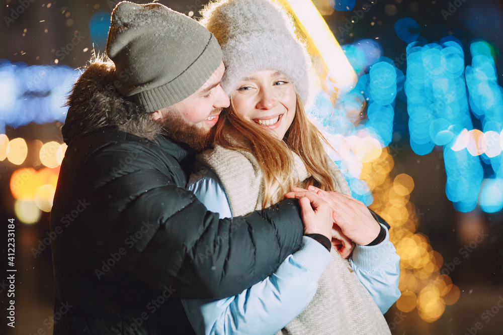 Obraz premium Winter holidays conception. Outdoor night portrait of young couple. Posing in street of European city.
