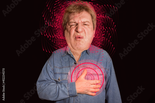 Portrait of old man with pain in a heart on black background photo
