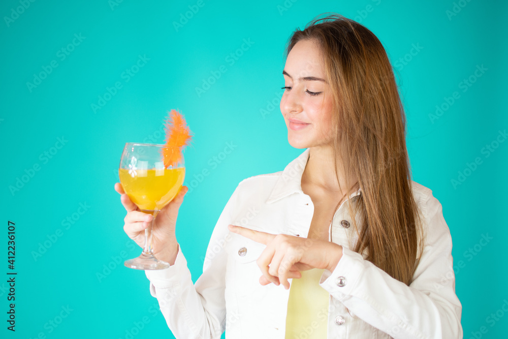Portrait of a beautiful casual girl drinking orange juice from a glass isolated over green background Portrait of a beautiful casual girl drinking orange juice from a glass isolated over green background