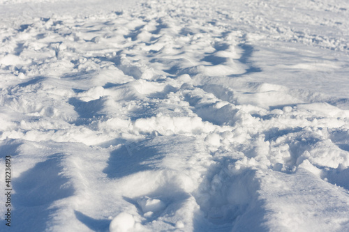 Snow in city park with footprints, winter concept on frosty sunny day