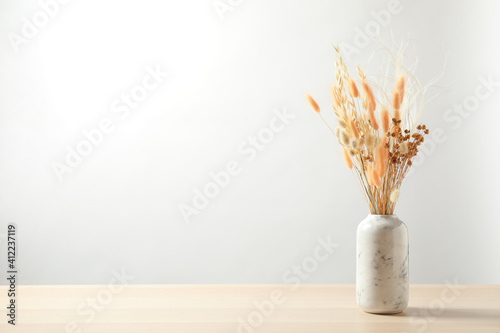 Fototapeta Naklejka Na Ścianę i Meble -  Dried flowers in vase on table against light background. Space for text
