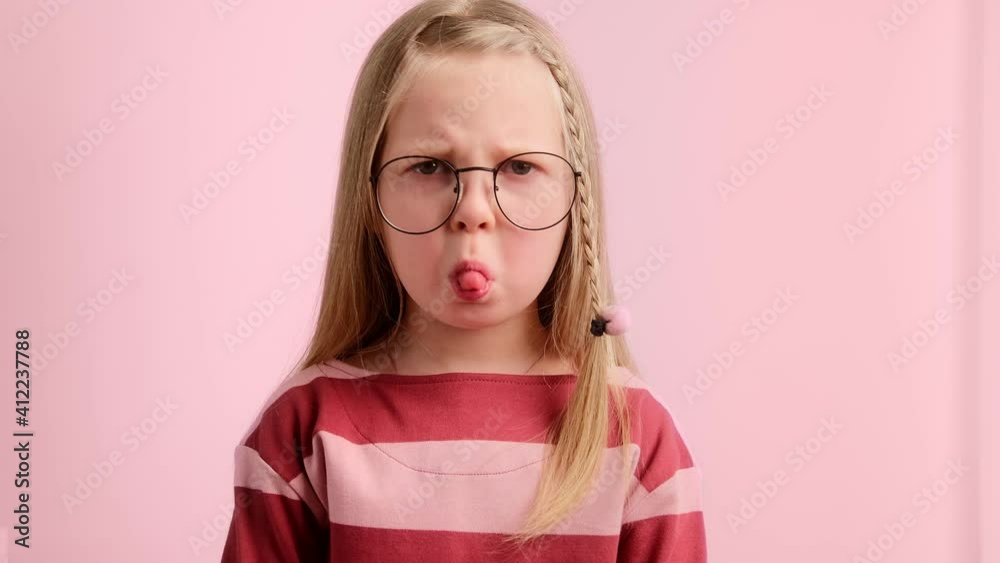 Little girl child angry and upset, frowning her brow and showing tongue. Bad mannered kid, naughty children. Little girl child angry and upset, frowning her brow and showing tongue. Bad mannered kid, naughty children.