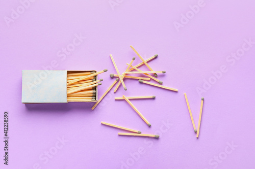 Box with matches on color background