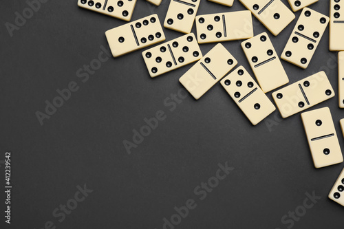 Fotografie Classic domino tiles on black background, flat lay
