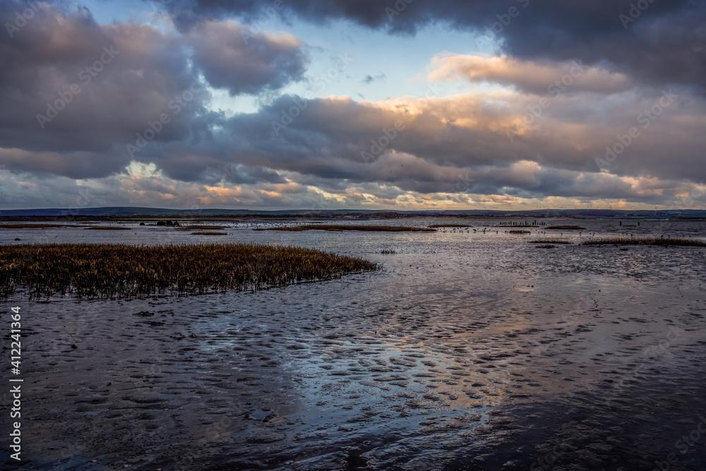 Evening clouds reflect on mud and water in the Skern area of Northam Burrows, near Appledore, North Devon.