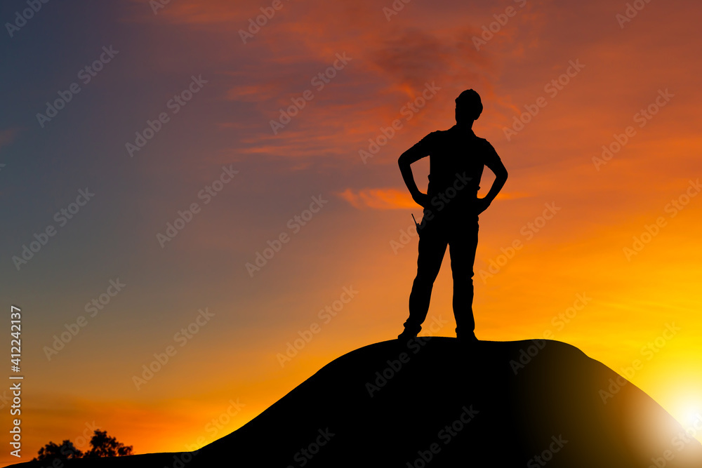 Silhouette of engineer man with clipping path on a mountain top sunset evening sky background