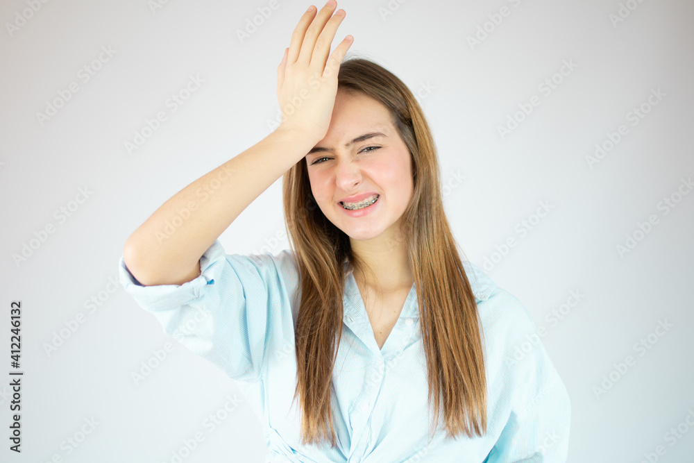 Portrait of preoccupied worried young girl in pink shirt putting hand on head isolated over white background. People lifestyle concept. Mock up copy space Portrait of preoccupied worried young girl in pink shirt putting hand on head isolated over white background. People lifestyle concept. Mock up copy space