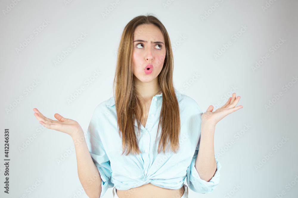 Young woman over isolated white background thinking an idea while looking up Young woman over isolated white background thinking an idea while looking up