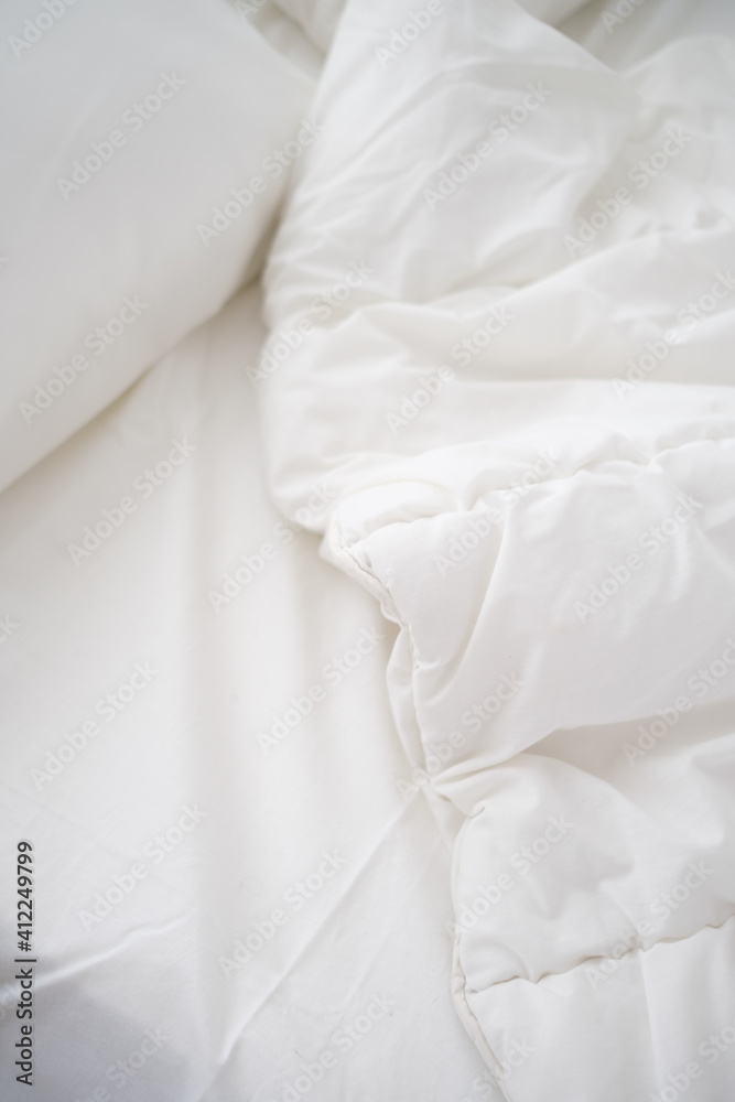 Obraz premium Soft white pillows on messy bed, closeup.