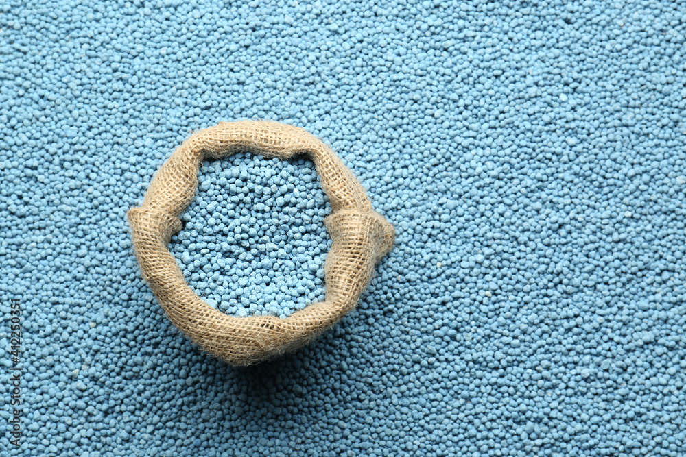 Sack bag and granular mineral fertilizer, top view with space for text Sack bag and granular mineral fertilizer, top view with space for text
