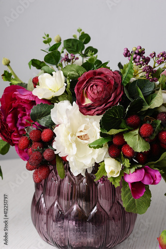 Elegant flower composition in purple vase. Tender bouquet ofred and ivory flowers on grey background. Interior decoration. Valentines day present. photo