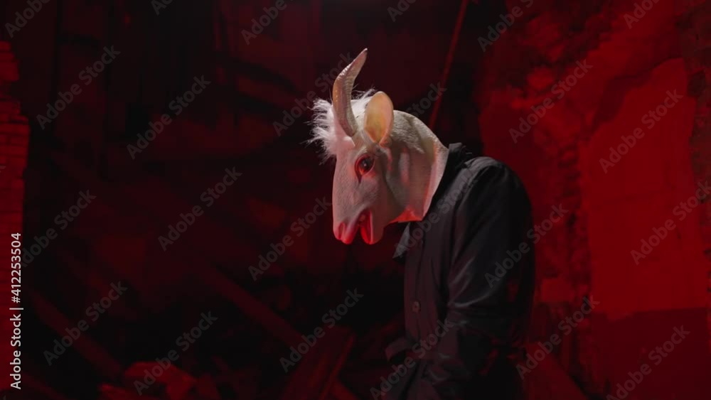 Devil looking at the camera. Creepy cultist in an abandonded, haunted house. Hell concept. Scary demon, mysterious masked man. Horror halloween scene. Devil looking at the camera. Creepy cultist in an abandonded, haunted house. Hell concept. Scary demon, mysterious masked man. Horror halloween scene.
