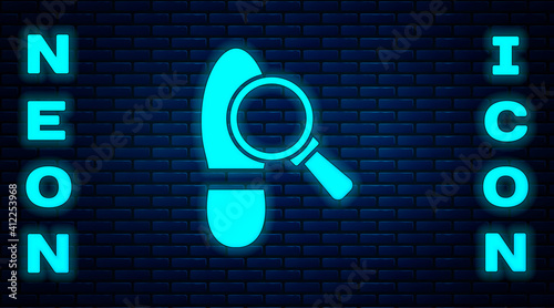 Glowing neon Magnifying glass with footsteps icon isolated on brick wall background. Detective is investigating. To follow in the footsteps. Vector.