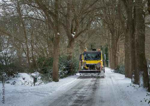 Truck with snowshovel clearing the road. Snow and frost. Winter at Rheebruggen estate Drenthe Uffelte Netherlands. Westerveld.