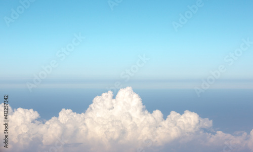 Beautiful white clouds on blue sky. View from inside airplane.