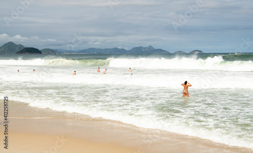   Citizens swim and sunbathe on the beach of Copacabana © aleks