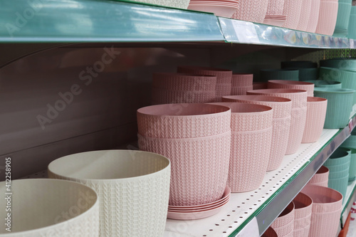 Flower pots on a store shelf. A cache-pot of delicate flowers.