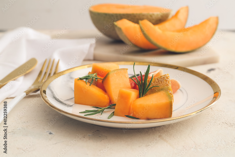 Plate with delicious melon and prosciutto on light background Plate with delicious melon and prosciutto on light background