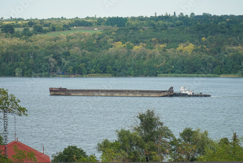 Foto A barge cargo ship is sailing along the river.