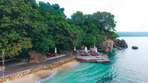 Drone view of beach chairs and umberella on tropical ocean beach in Moyo Island, Sumbawa, Indonesia