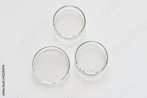 three empty glass Petri dishes on a laboratory table. sterile lab dishes ready for tests. analysis and chemical experiment. cell culture growing equipment. top view.