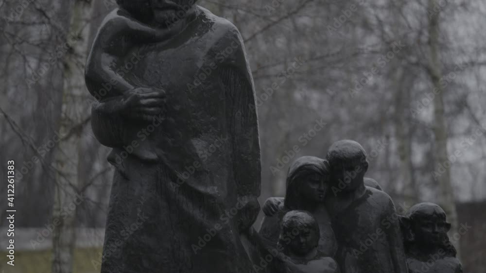 A concrete\stone monument inside a Jewish cemetery while raining. the camera moves slowly over the statue's details in a telephoto lens, a 4K (Sony S-Log) clip, Warsaw, Poland.