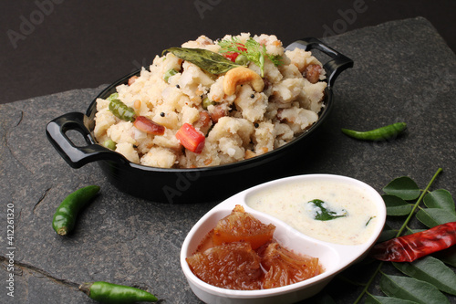 Rice upma, a south Indian vegetarian breakfast made from shredded rice and vegetables like carrot andpeas, with coconut chutney as a side dish.
