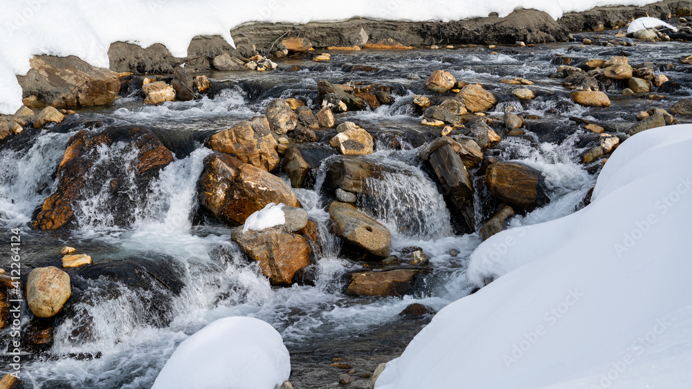 a mountain creek in the spring with water of melting snow a mountain creek in the spring with water of melting snow