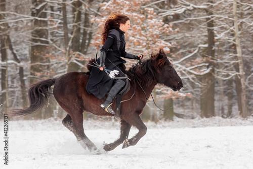 young woman riding in historical costume as a warrior and passes by quickly