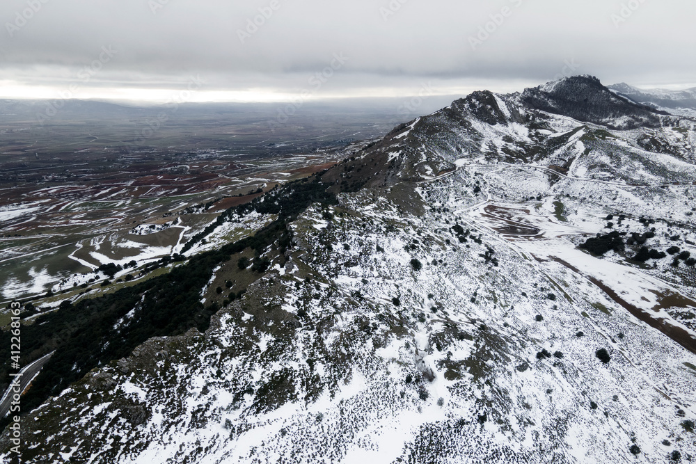 Aerial view over snow covered high mountains. High quality photo.