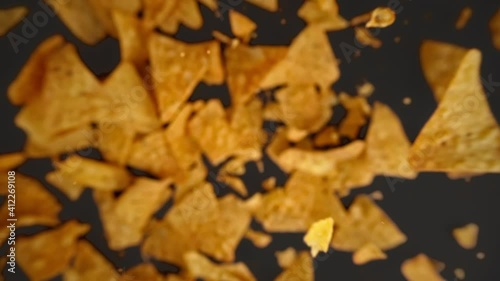 Slow motion of flying nachos chips on a black background