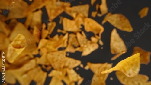 Slow motion of flying nachos chips on a black background
